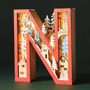 Detailed view of LED wooden letter N featuring a layered winter forest and reindeer scene