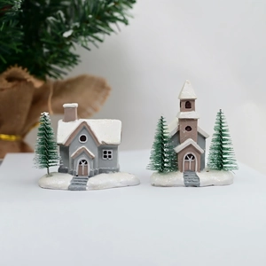 Miniature resin Christmas village houses with snowy details and green pine trees