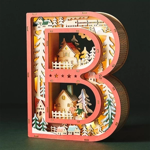 Macro detail of wooden letter B LED light showing layered winter village wood carving scene