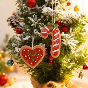 Christmas gingerbread heart and candy cane hanging ornaments on snowy tree