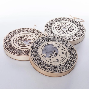Detail of wooden Ramadan moon and star ornaments with laser-cut geometric patterns