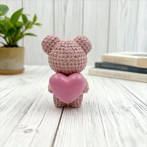 Charming resin bear figurine with knit texture holding a pink heart for home decor