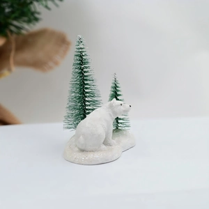 Gros plan d'une figurine d'ours polaire avec des sapins enneigés décoration de Noël