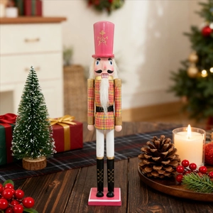 Dettaglio di schiaccianoci re in legno a quadri rosa e gialli su tavolo in legno