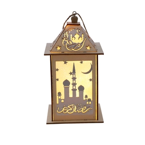 Close-up of wooden Ramadan lantern with LED light showing mosque cutout and gold calligraphy