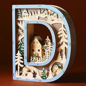 Detail of wooden letter D LED light featuring laser-cut 3D winter forest scene