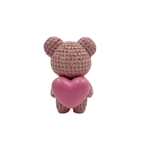 Pink resin teddy bear figurine with knitted texture holding a heart for desk decor