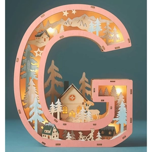 Macro detail of wooden letter G LED light featuring laser-cut winter forest scene inside