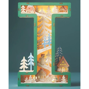 Close-up of wooden letter I lamp with laser-cut winter cabin and warm LED lights