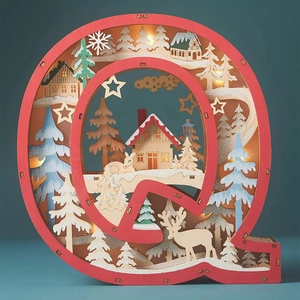 Detail of red wooden letter Q LED light with laser-cut winter forest and reindeer scene