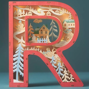 Detail of laser-cut wooden letter R lamp with warm LED winter forest and cabin scene
