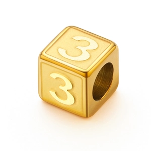 Macro detail of golden cube bead with number 3 engraving for jewelry making