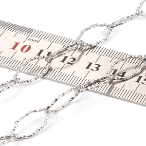 Diamond-shaped stainless steel link chain with textured surface shown next to a ruler