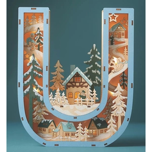 Macro view of wooden letter U lamp with intricate hollowed winter forest scene
