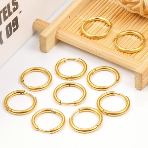 Set mit 10 polierten goldenen Edelstahl-Ohrringen auf einem dekorativen Bambustablett