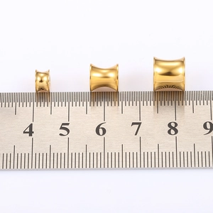 Polished 18K gold plated stainless steel ear tunnels in three sizes with a scale ruler