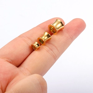 Close-up of three graded sizes of 18K gold-plated stainless steel ear tunnels for gauges