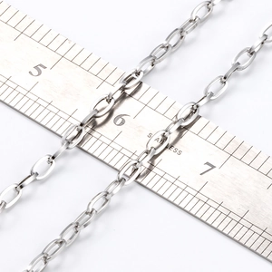 Catena a croce in acciaio inossidabile argento da 2-3 mm posata su un righello metallico