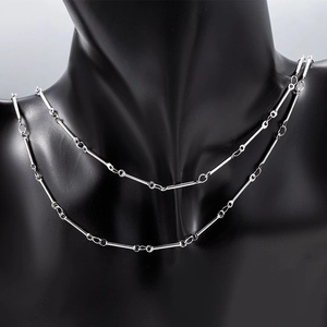 Detail of silver stainless steel stick and ring chain necklace on black mannequin