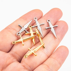 Detailopname van gouden en zilveren kruiszwaardhangers op de palm voor de grootte