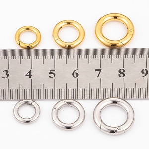 Macro detail of 316 stainless steel spring rings in gold and silver with size ruler