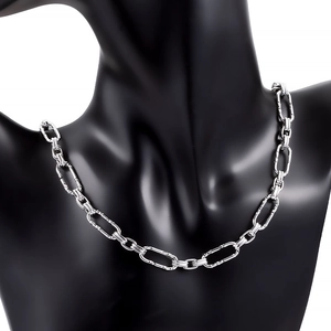 Close-up of chunky stainless steel curb chain necklace with textured oval links on model