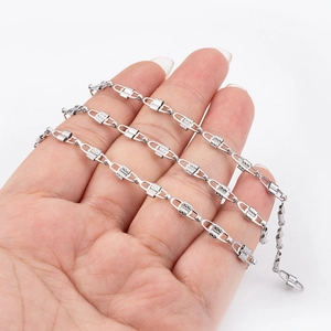 Detailed close-up of a silver stainless steel textured link chain necklace on hand