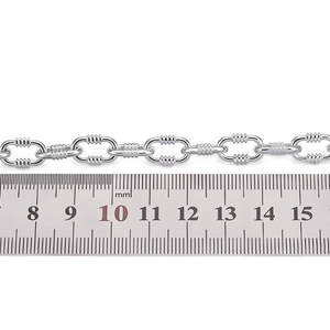 Close-up of stainless steel oval link chain with textured spiral patterns and size ruler