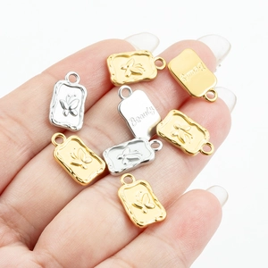 Detail view of rectangular butterfly pendants in gold and silver finish with Beauty engraving