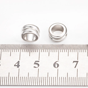 Vue macro de perles en acier inoxydable de 10mm avec trou de 6mm sur une règle graduée