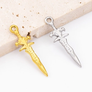Detailed view of silver and gold sword pendants with intricate engravings on stone base