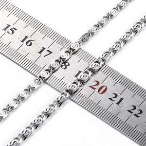 Primer plano de cadena de acero inoxidable con medidas en una regla de metal