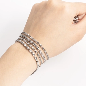 Primer plano de pulsera y anillo de acero inoxidable plateado en la mano de alguien