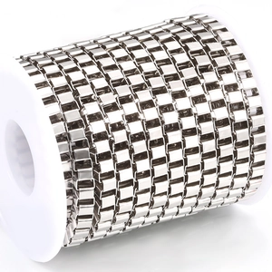 Macro detail of bulk stainless steel box chain wound on a white spool for DIY jewelry