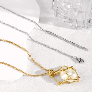 Detail of adjustable stainless steel mesh cage necklace with gold finish and pearl insert