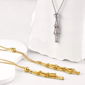Detailed macro view of adjustable stainless steel cage necklaces in gold and silver finish