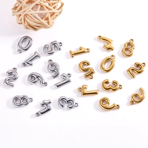 Detailed view of polished 18K gold and silver stainless steel bubble number charms for DIY jewelry