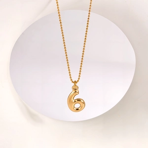 Detail view of 18K gold plated stainless steel bubble number 6 pendant on ball chain
