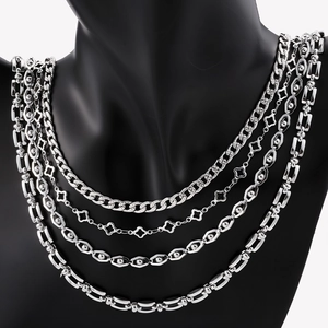 Detail of four silver-plated stainless steel chains with clover and geometric link designs