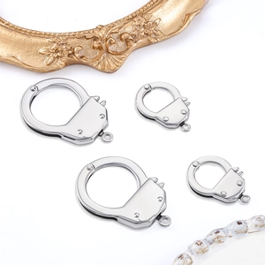 Macro detail of polished stainless steel handcuff charms in two sizes for DIY jewelry making