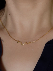 Nahaufnahme der goldenen Schlangenkette mit detaillierten Schuppen an einem Model