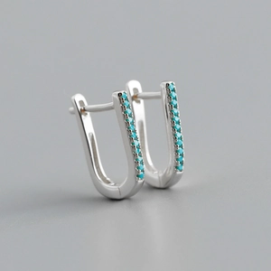 Macro shot of S925 sterling silver huggie earrings with inlaid turquoise cubic zirconia