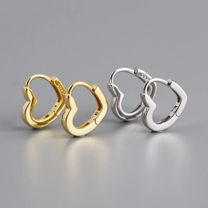 Gros plan de créoles en forme de cœur en argent sterling 925, finitions or et argent