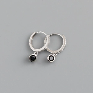Macro du poinçon argent S925 et du pendentif en pierre noire sur la boucle d'oreille