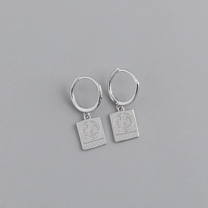 Detalle de pendientes de aro en plata S925 con colgante grabado de la Torre Eiffel