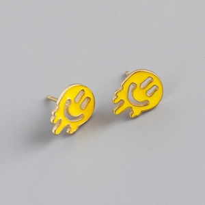 Detailed close-up of yellow melting smiley face stud earrings with gold plating