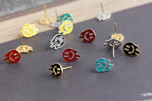 Macro shot of colorful melting smiley face stud earrings in red, yellow, and green