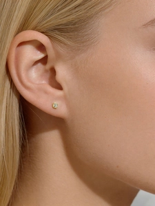 Close-up of a minimalist square zirconia stud earring in a gold-plated setting on ear