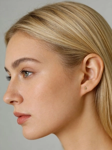 Close-up of minimalist S925 silver square stud earrings with zircons on a model's ear