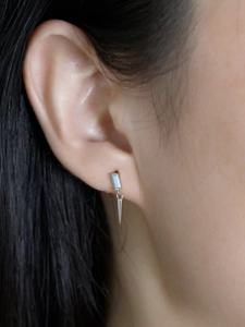 Détail de la boucle d'oreille en argent avec zircon bleu et cône métallique poli